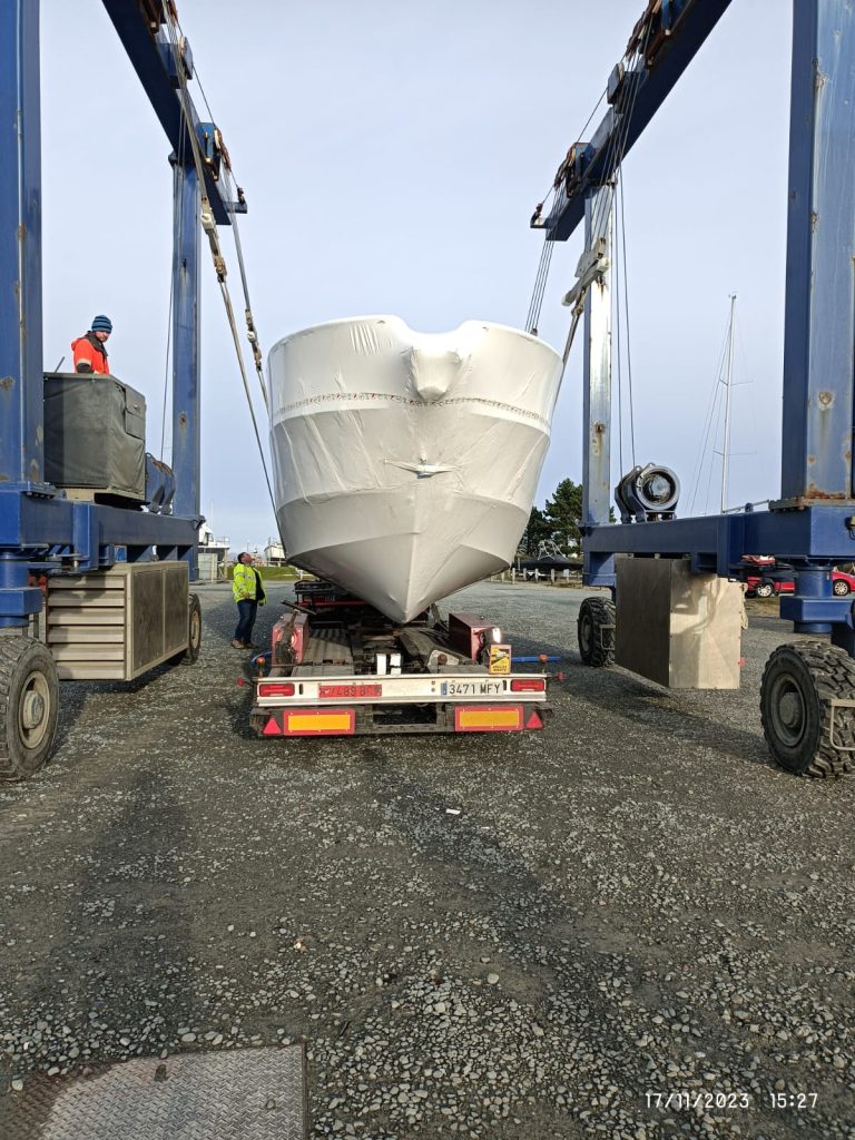 Ein Boot wird mit einem Kran auf einen Lastwagen gehoben.