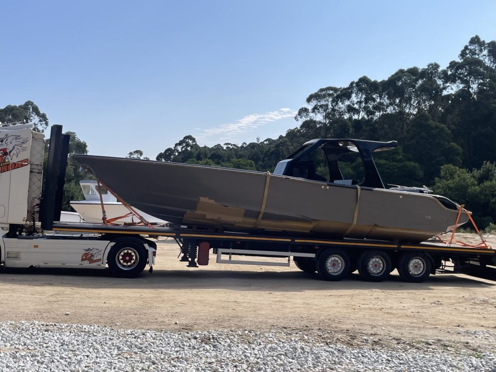 Kran hebt Boot für den Transport auf einen Lkw