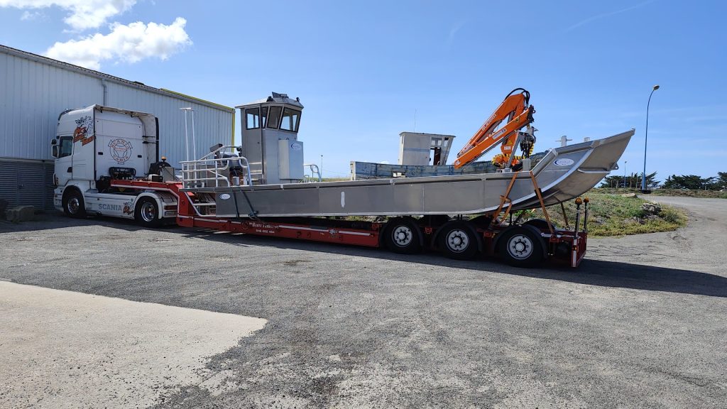 Ein großer Boot wird von einem Truck gezogen.