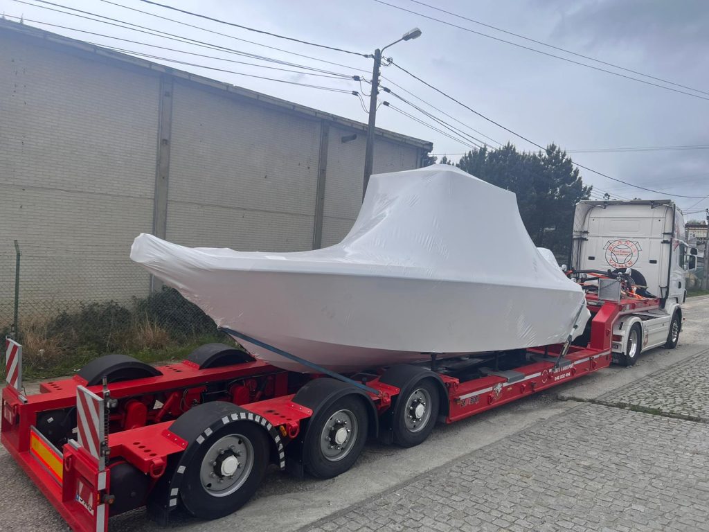 Kranverladung eines Bootes auf einen Transport-Lkw